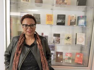 Poet Patricia Spears Jones stands in front of a case of books